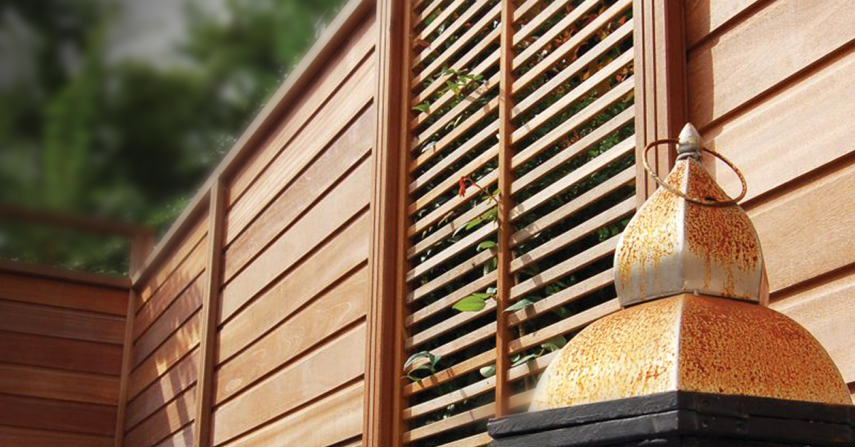 Horizontal wood fence with a decorative lattice panel. A rustic metal lantern adds charm to the outdoor setting.